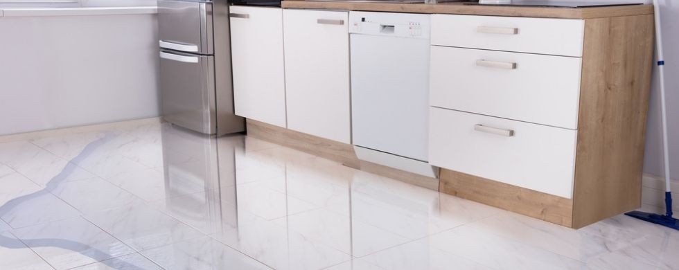 Modern kitchen with white cabinetry, appliances, and polished floor, highlighting A & W Plumbing and Heating, Inc. services.