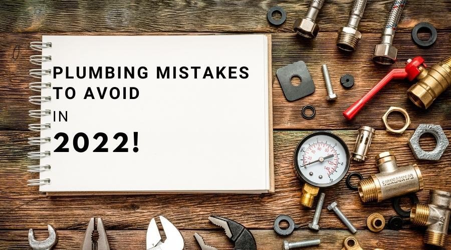 Open notebook titled "PLUMBING MISTAKES TO AVOID IN 2022" with plumber’s tools on wood, related to A & W Plumbing services.
