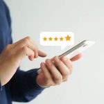Individual using smartphone with five-star rating graphic, showcasing A & W Plumbing and Heating service reviews.