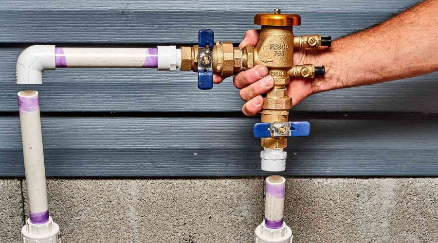 Brass water control valve assembly with PVC pipes, demonstrating plumbing operation by A & W Plumbing and Heating, Inc.