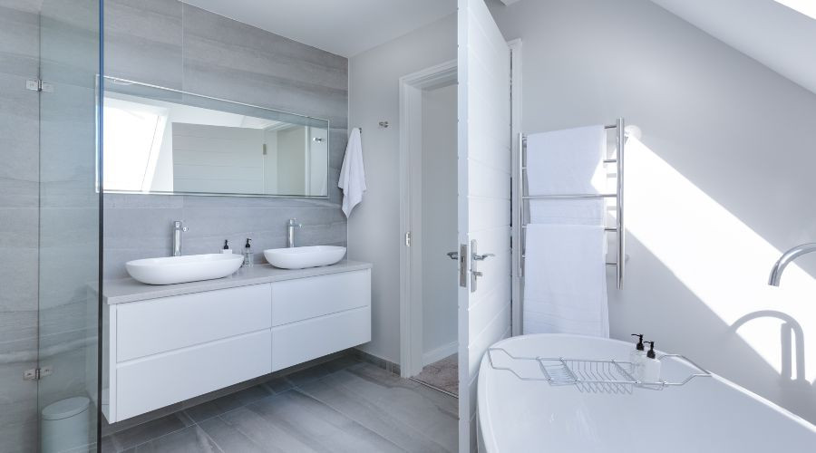 A modern bathroom interior featuring a minimalist design with a focus on white and gray tones.
