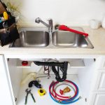 Kitchen sink with plumbing tools and maintenance supplies, illustrating plumbing maintenance services by A & W Plumbing and Heating, Inc.