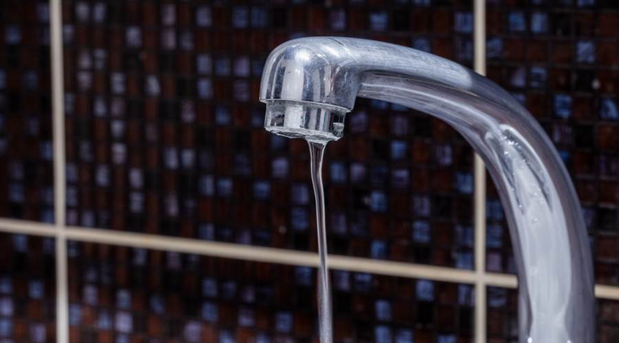 Faucet with water dripping, illustrating low water pressure issues relevant to plumbing services by A & W Plumbing and Heating, Inc.